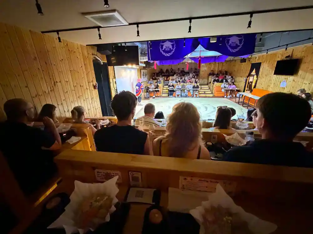 Crowd watching sumo wrestling match from elevated seating