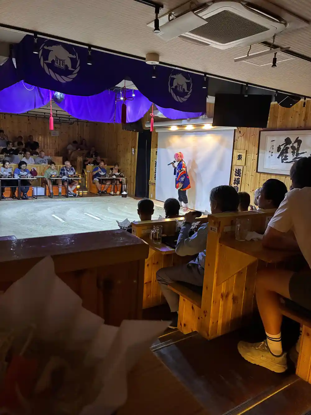 Group photo with sumo wrestlers and visitors in hall