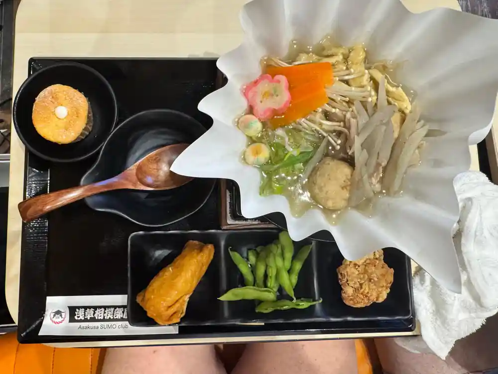 Japanese meal with grilled items and vegetables on black tray