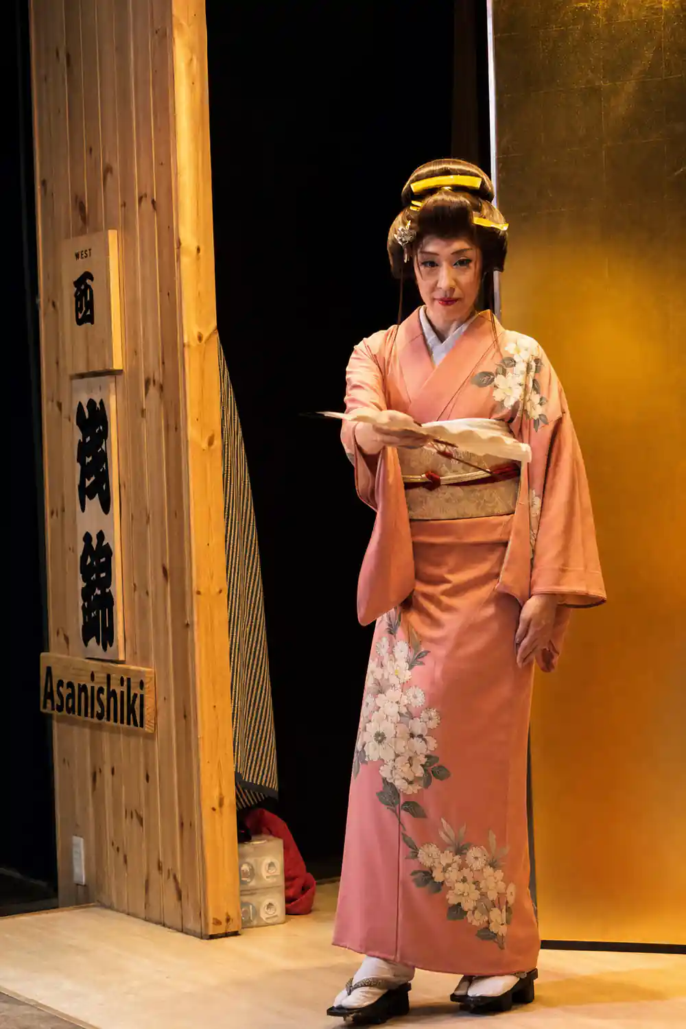 Person in traditional Japanese kimono on stage with fan