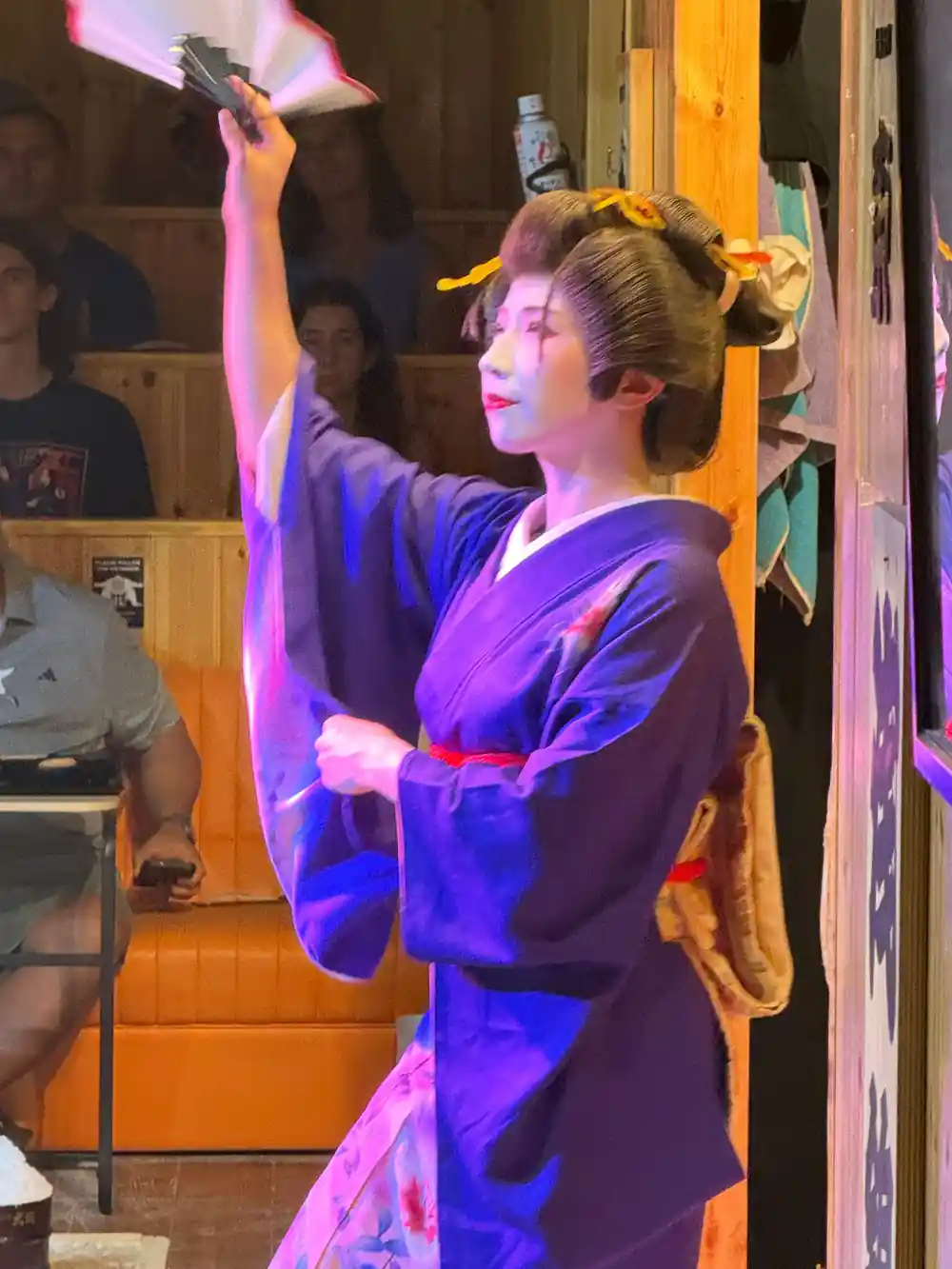 Person in purple traditional robe performing with white cloth