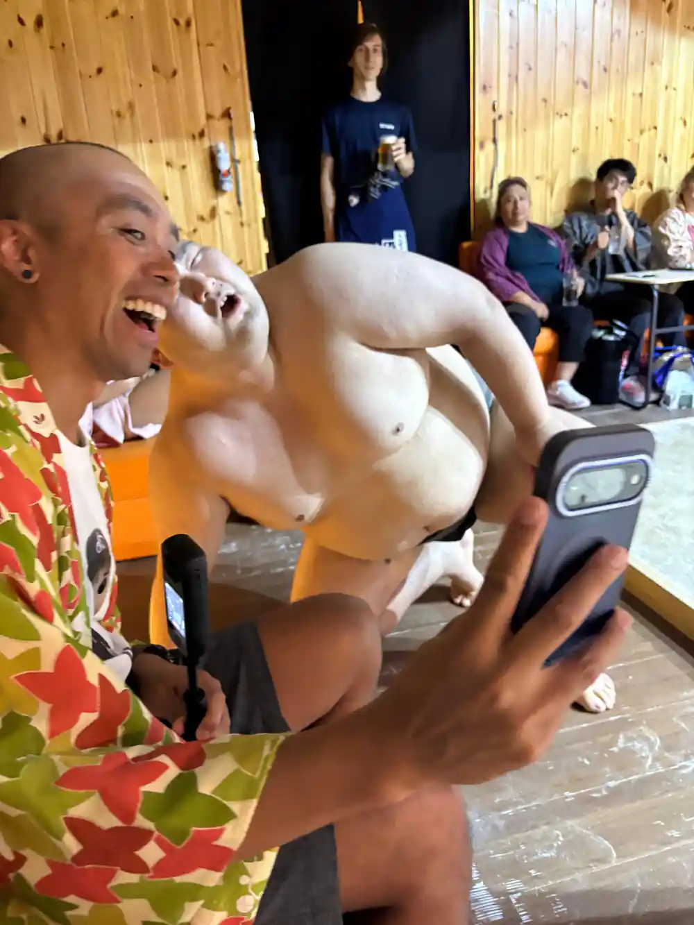 Sumo wrestler being held up while eating