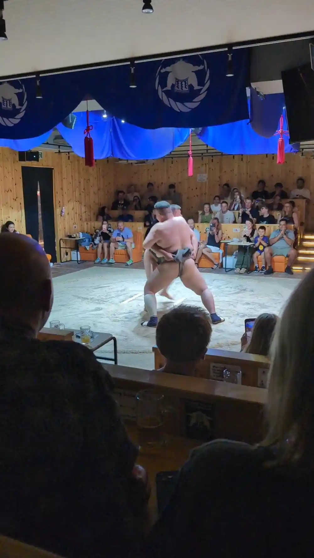 Sumo wrestler in ring with audience seated around