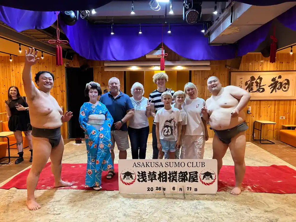 Sumo wrestler on stage with spectators watching performance