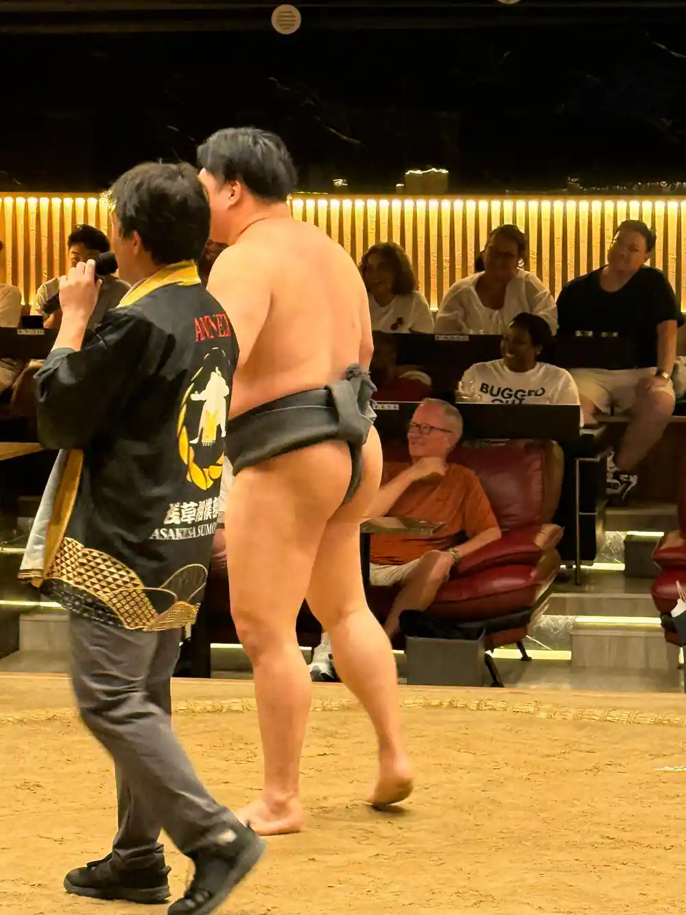 Sumo wrestler talking with official during tournament