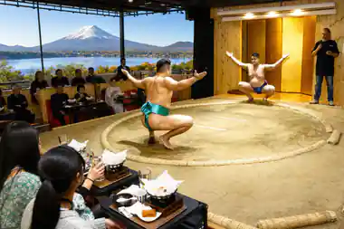 Sumo wrestlers performing in sand ring with spectators