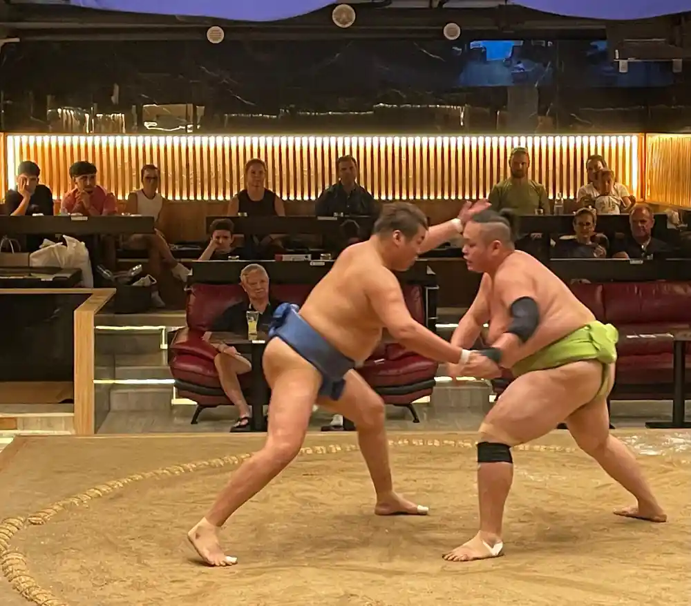 Two sumo wrestlers grappling in traditional ring match