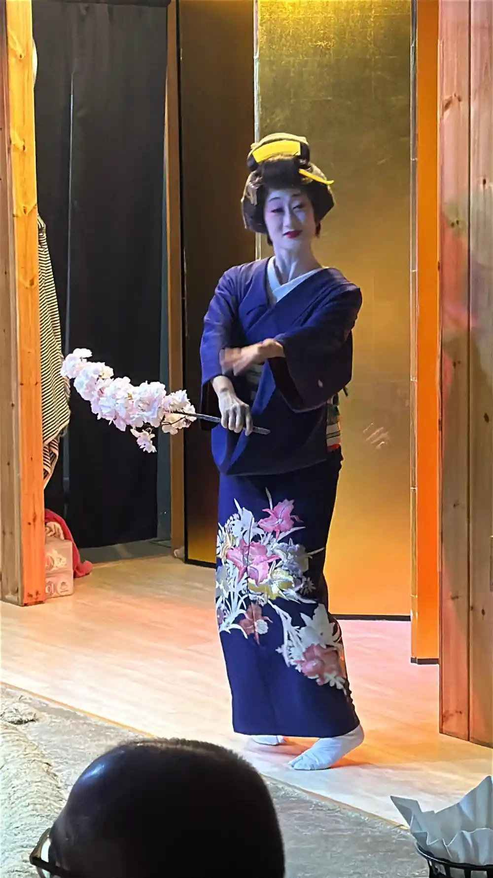 Woman in blue kimono with fan and yellow hat