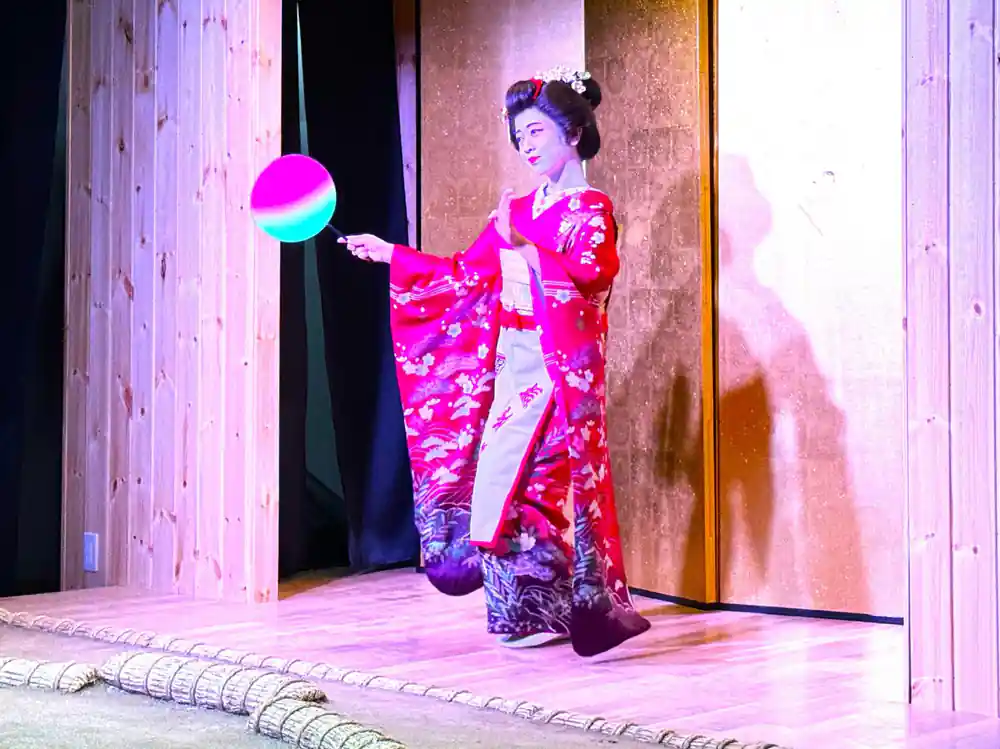Woman in pink kimono performing with glowing ball